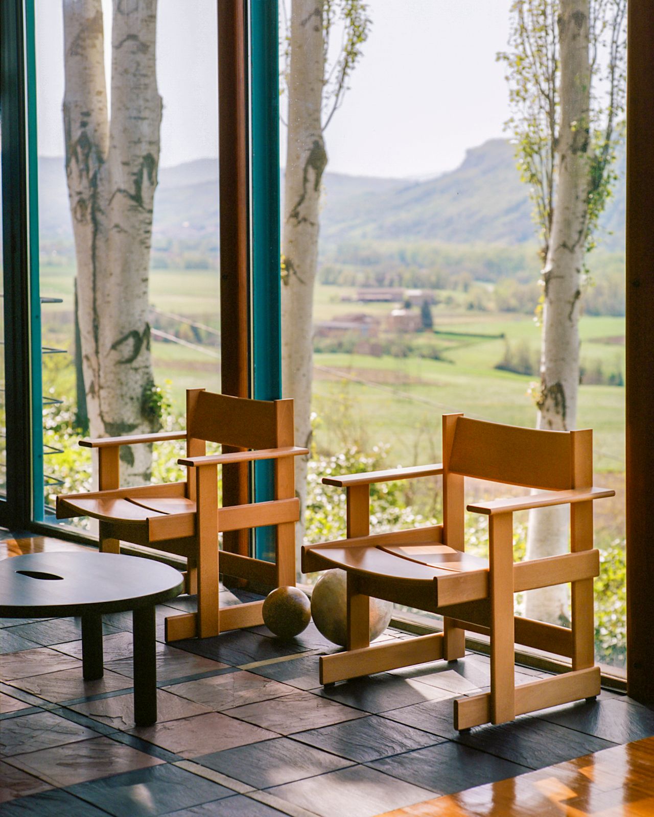 A lifestyle image of a lounge scene featuring Bullnose Lounge Chairs and Worm Table.