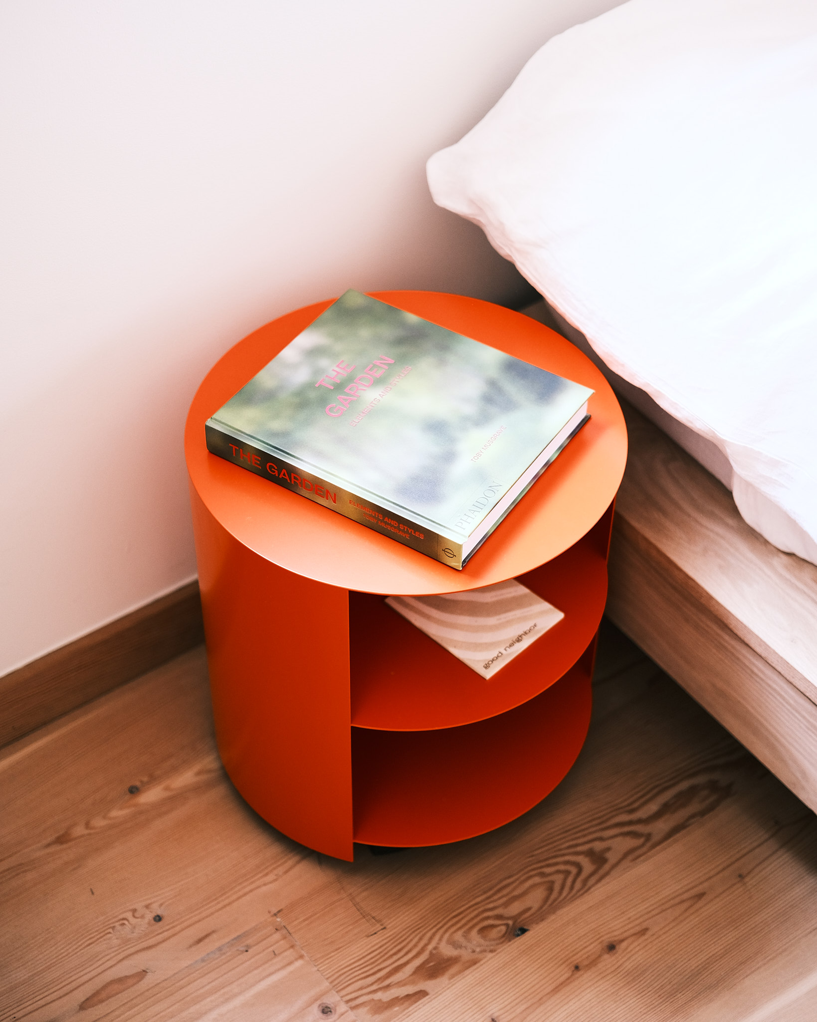 [Hide Side Table Pure Orange](/furniture/tables-and-side-tables/hide/14154) used as a nightstand in one of the guesthouse rooms.