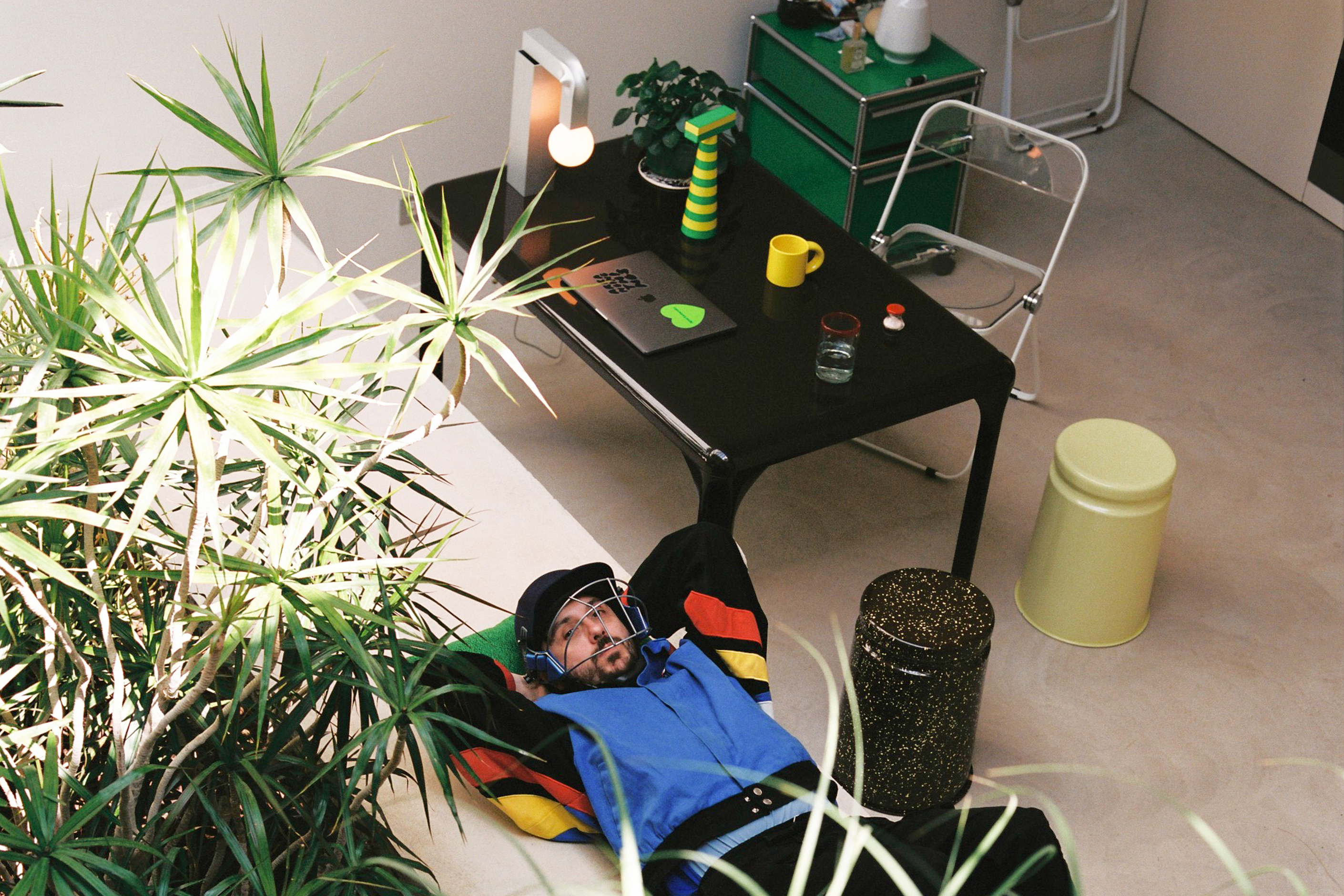 An editorial image of a lounge scene featuring Last Stool, Molino Grinder, Knuckle Table Lamp, and Bronto Mug.