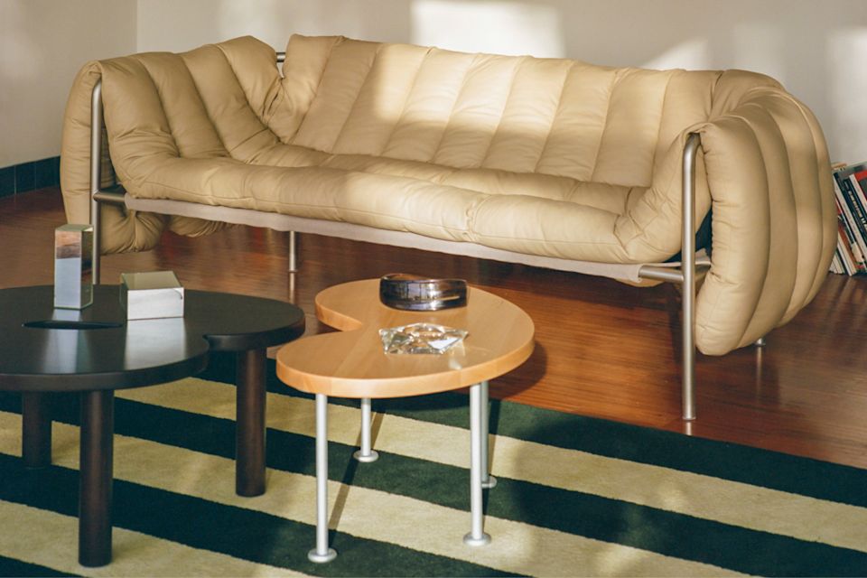 A lifestyle image of a lounge scene featuring Pattern Rug, Puffy Sofa, and Worm Tables.