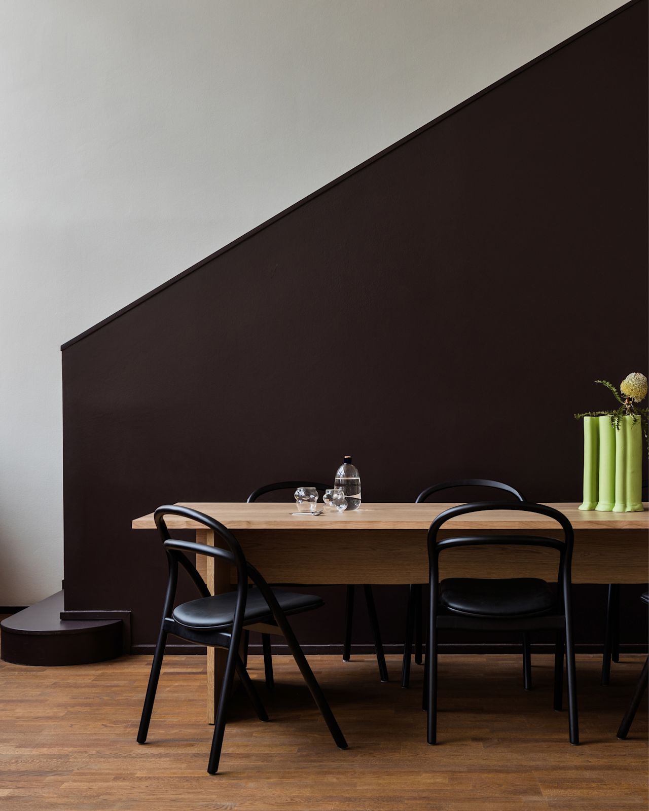 A lifestyle image of a dining scene featuring Bookmatch Table and Udon Chairs.