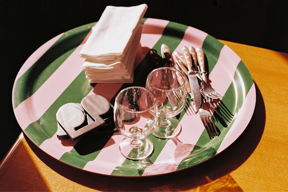 A lifestyle image of a dining scene featuring Stripe Tray and Disco Coasters.