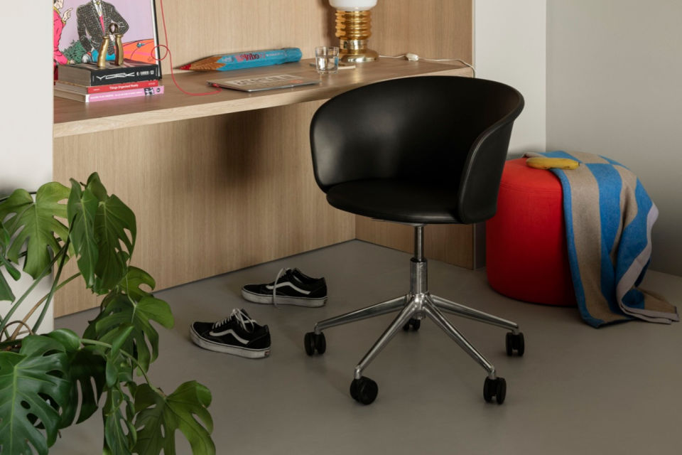 A lifestyle image of an office scene featuring Kendo Swivel Chair 5-star Castors, Bon Pouf Round, and Stripe Throw.