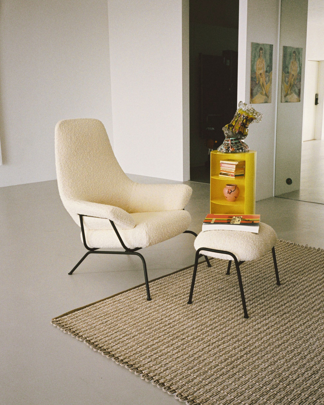 An analog image of a lounge scene featuring Hide Pedestal, Rope Rug, and Hai Lounge Chair + Ottoman.