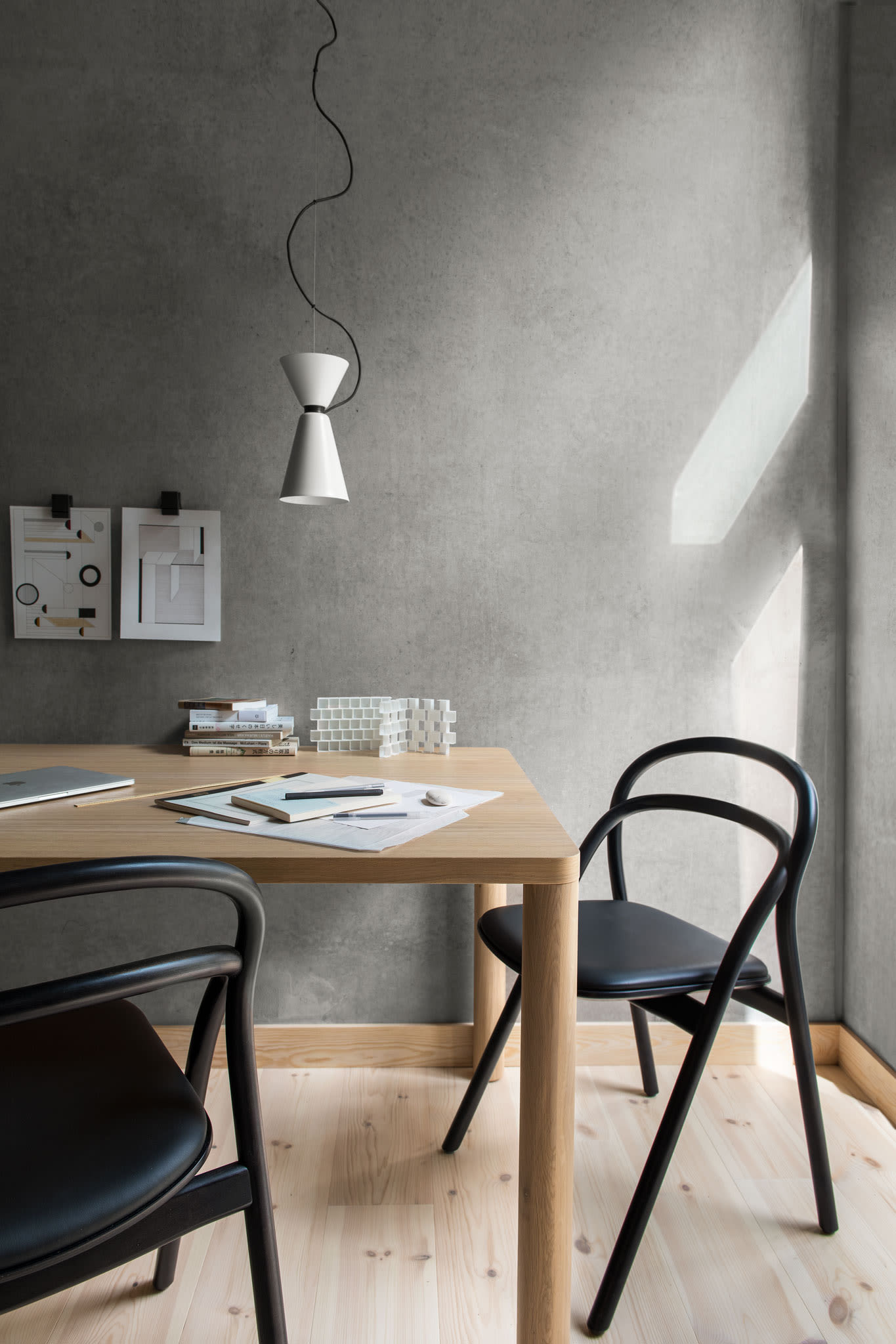 A lifestyle image of an office scene featuring Log Table, Udon Chairs and Alphabeta Pendant Light.