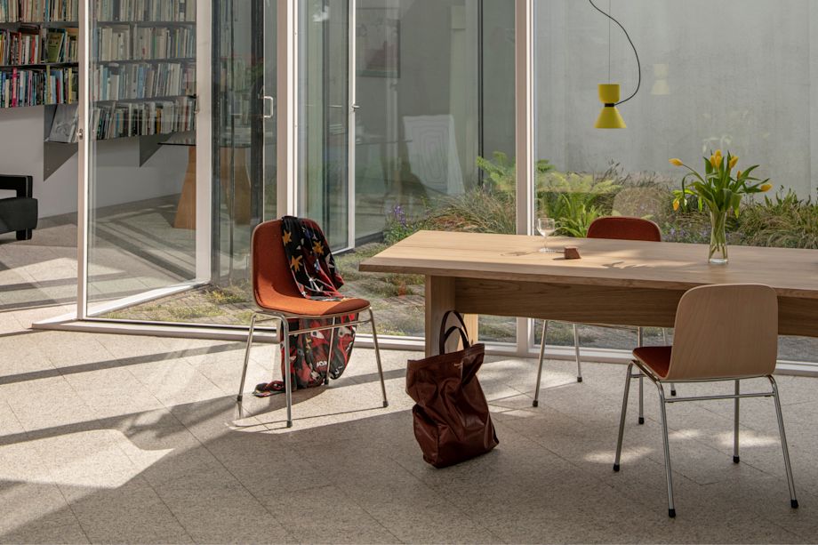 A lifestyle image of a dining scene featuring Bookmatch Table, Alphabeta Pendant Light, and Touchwood Chairs.