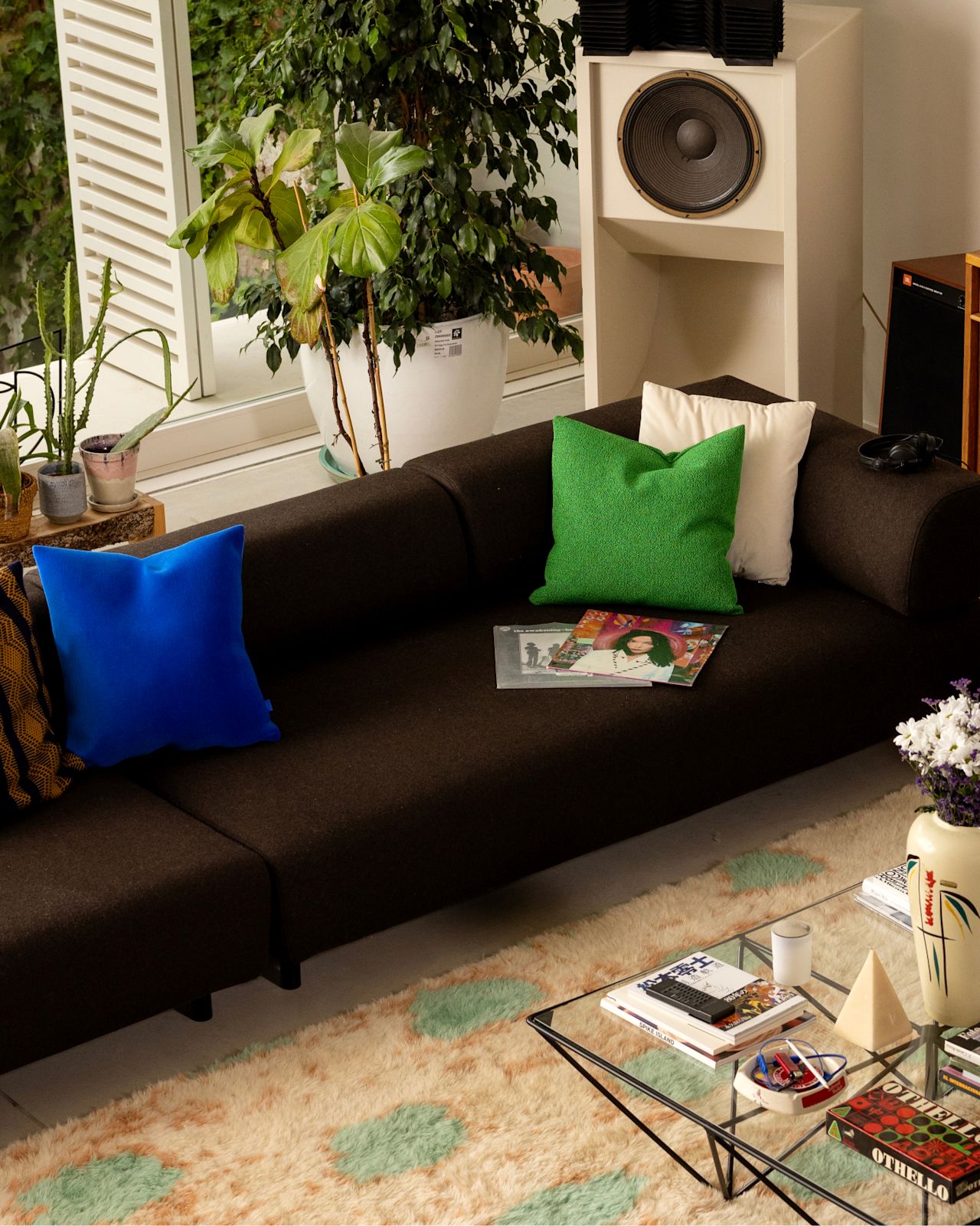 A lifestyle image of a living room/lounge scene featuring Palo Modular Sofa, Velvet Cushion, Crepe Cushion, and Monster Rug.