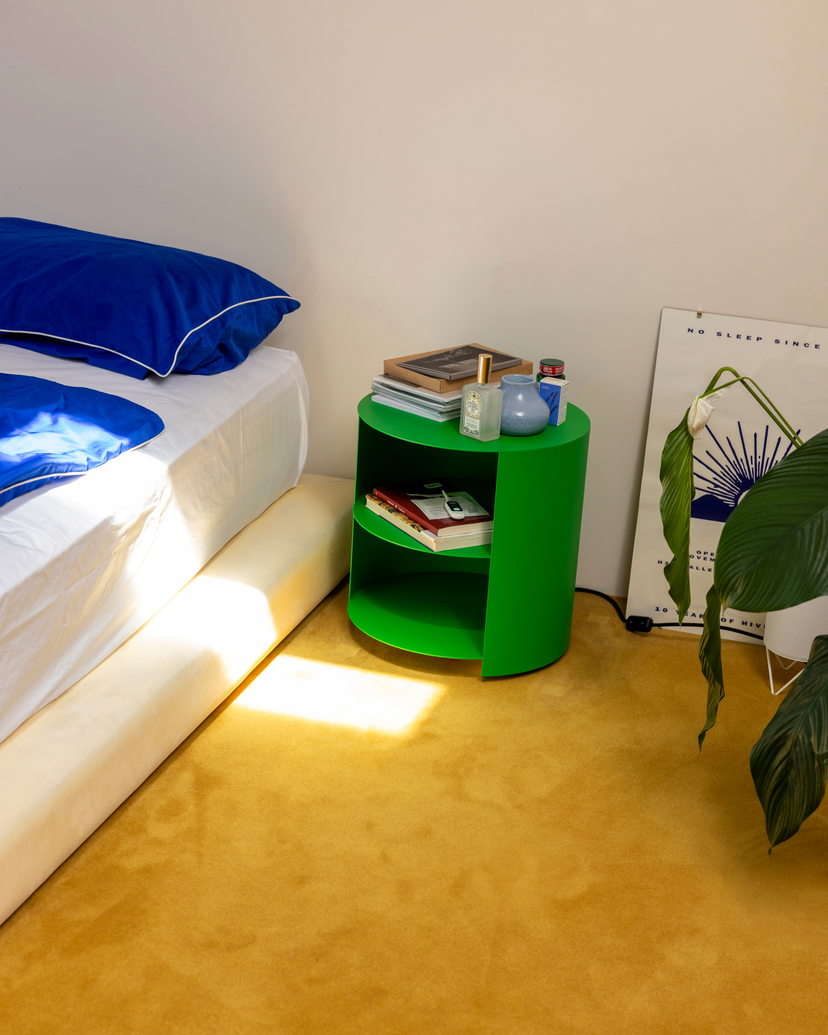 A lifestyle image of a bedroom scene featuring Hide Side Table Pure Green.