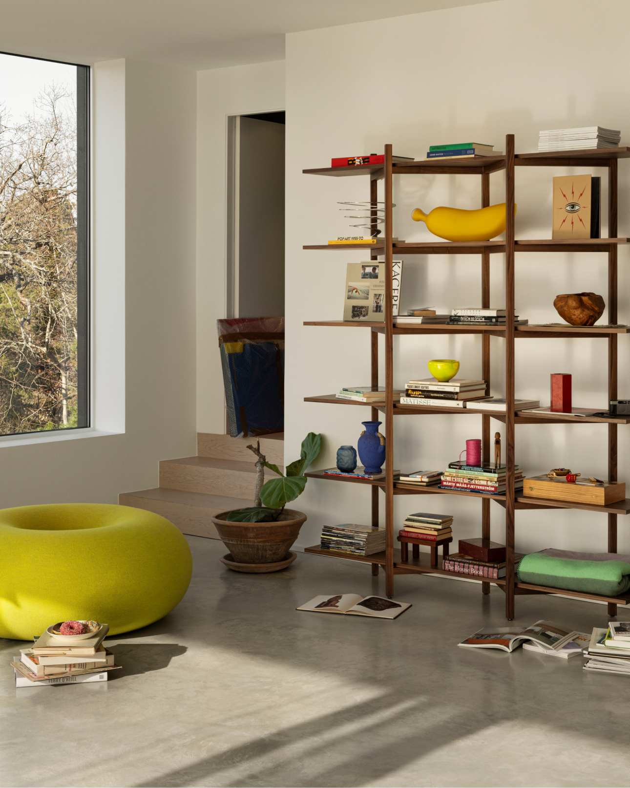 A lifestyle image of a lounge scene featuring Zig Zah High Shelf and Boa Pouf.