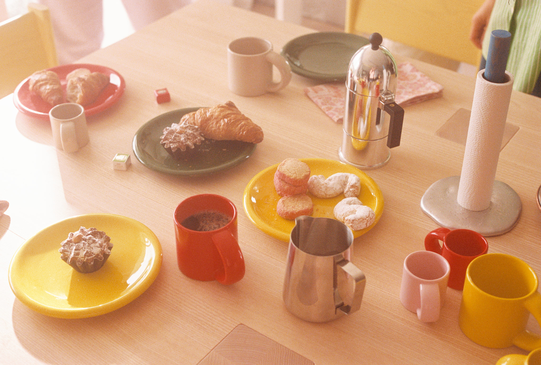 A lifestyle image of a dining scene featuring Bronto Tableware - Espresso cups, mug and plates - along with Spill Kitchen Roll Holder on the Max Table.