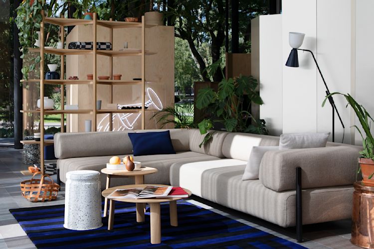 A lifestyle image of a lounge scene from the Hem Headquarters in Stockholm, Sweden in 2018 featuring Palo Modular Sofa, Alphabeta Floor Lamp, Zig Zag High Shelf, Last Stool, Alle Coffee Table, Stripe Rug, Last Stool, and Neo Cushion.