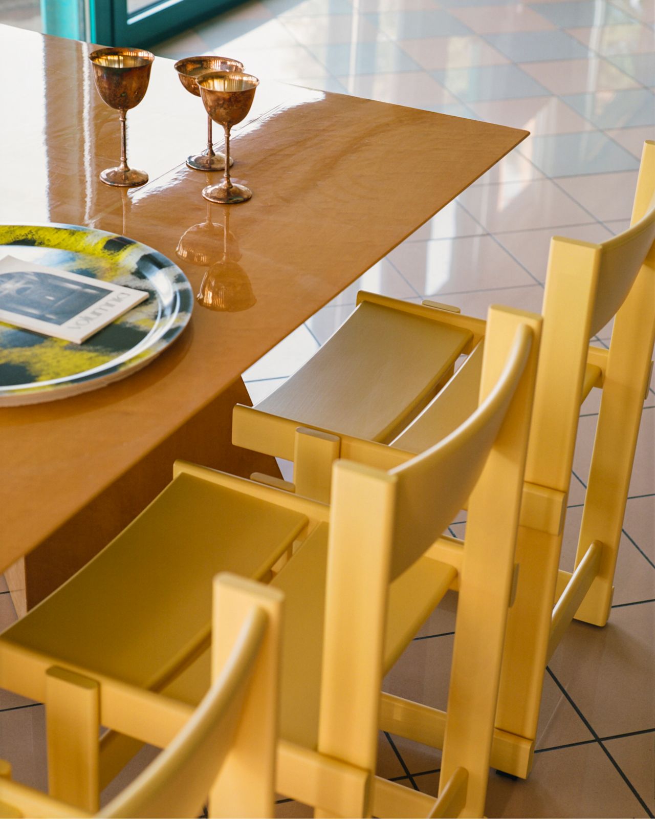 A lifestyle image of a dining scene featuring Bullnose Chairs and Monster Tray.