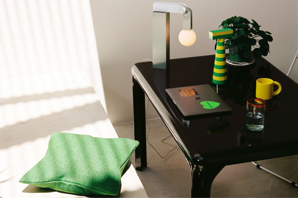 A lifestyle image of an office scene featuring Crepe Cushion, Knuckle Table Lamp, Molino Grinder, and Bronto Mug.