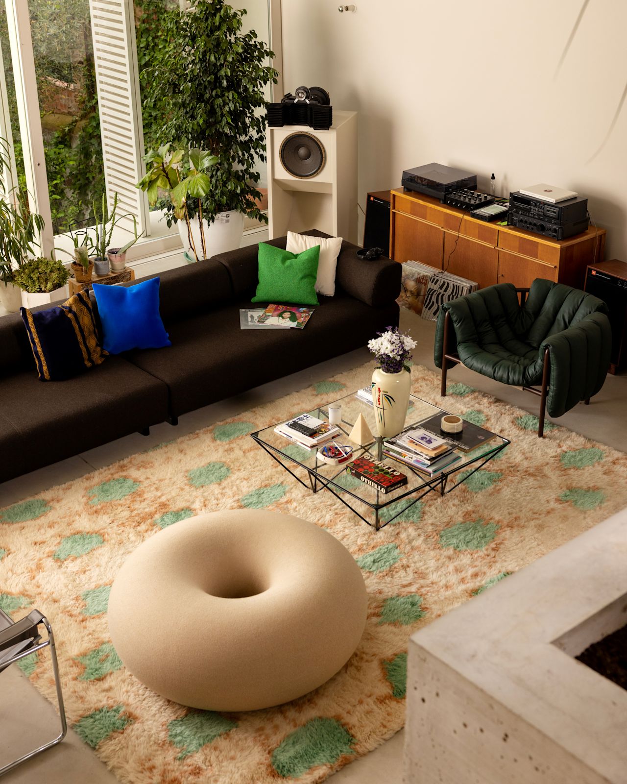 A lifestyle image of a living room / lounge scene featuring Palo Modular Sofa, Monster Rug, Velvet Cushion, Crepe Cushion, Puffy Lounge Chair, and Boa Pouf.