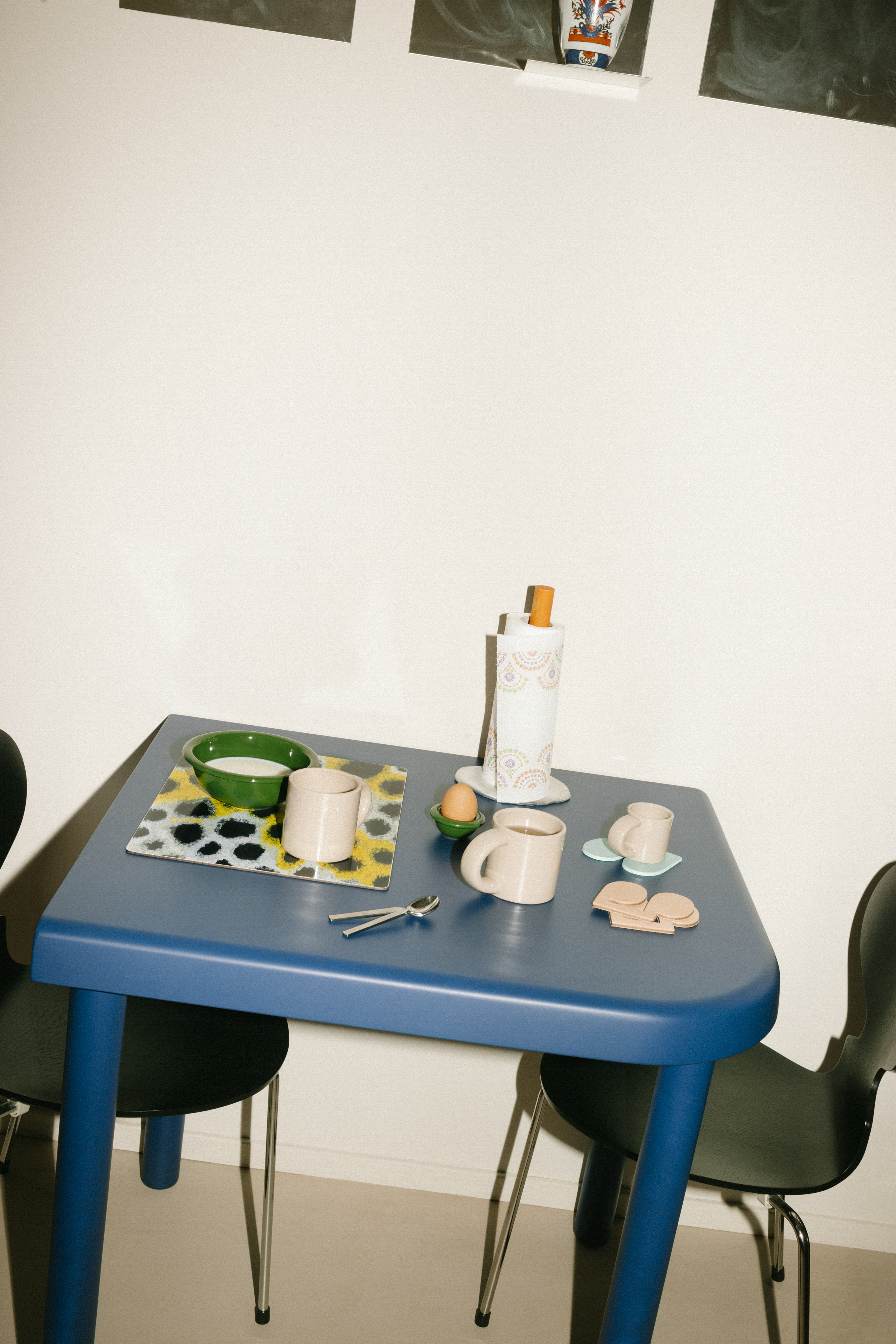 A lifestyle image of a kitchen/dining scene featuring Spill Kitchen Roll Holder, Monster Placemat, Disco Coasters, and Bronto Tableware.