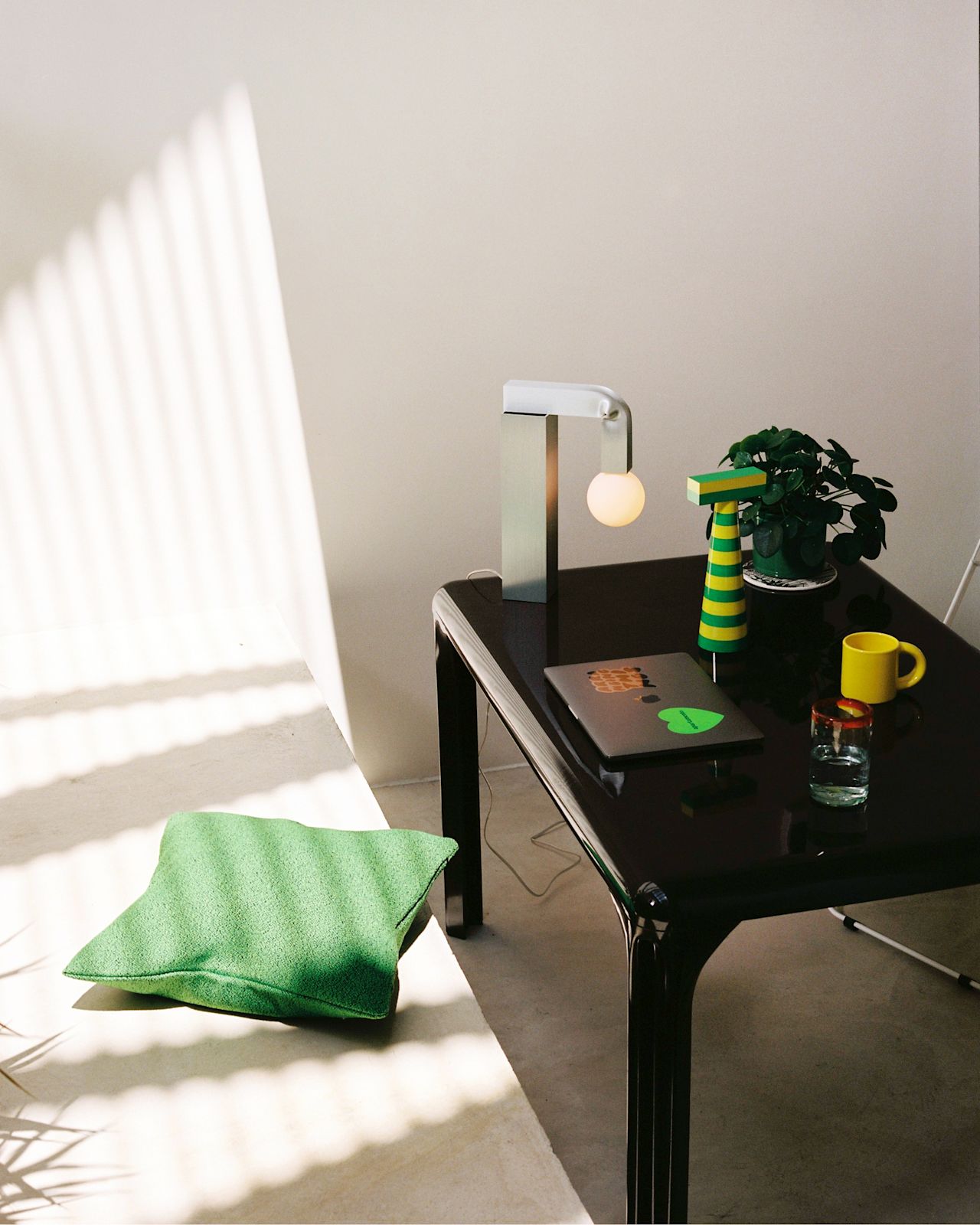 A lifestyle image of a lounge/office scene featuring Molino Grinder, Knuckle Table Lamp, Crepe Cushion, and Bronto Mug (Set of 2).