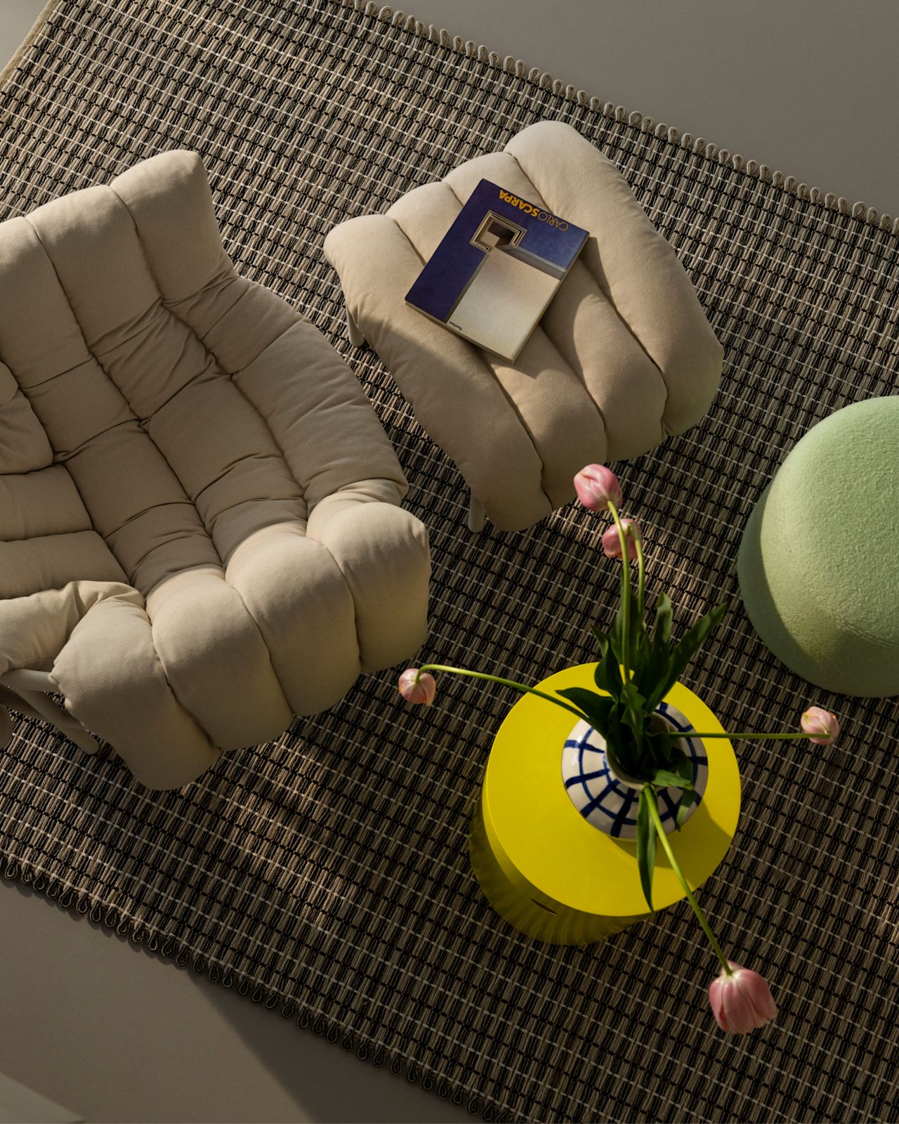 A lifestyle image of a lounge scene featuring Puffy Lounge Chair, Rope Rug, Hide Pedestal, and Bon Pouf.