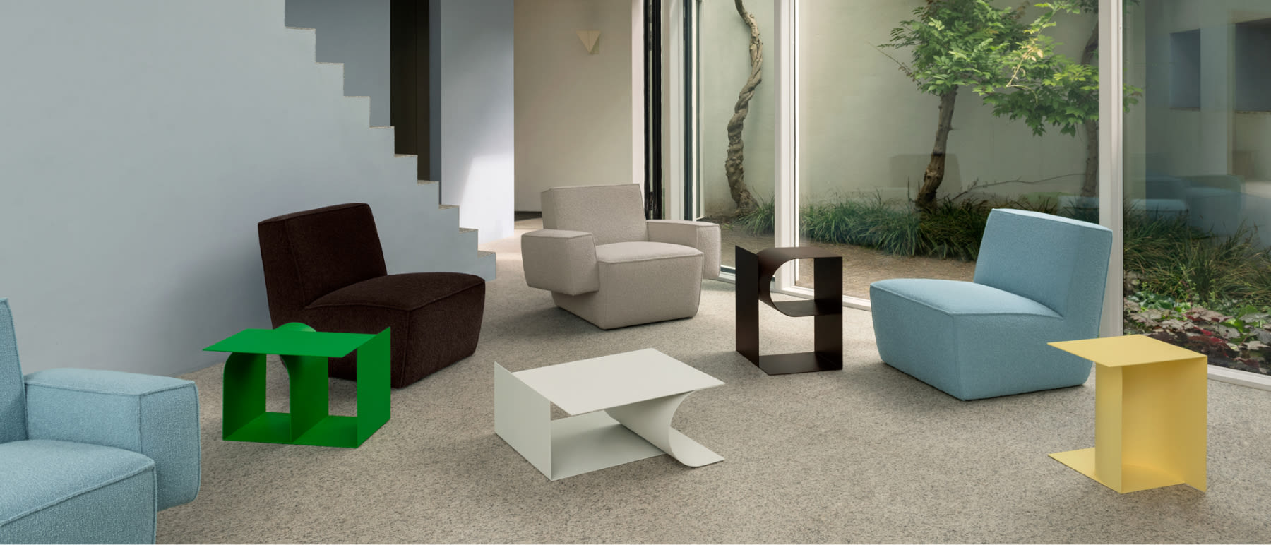 A lifestyle image featuring Hunk Lounge Chair, Hunk Lounge Chair with Armrests, and Glyph Side Tables Alpha, Beta and Gamma.