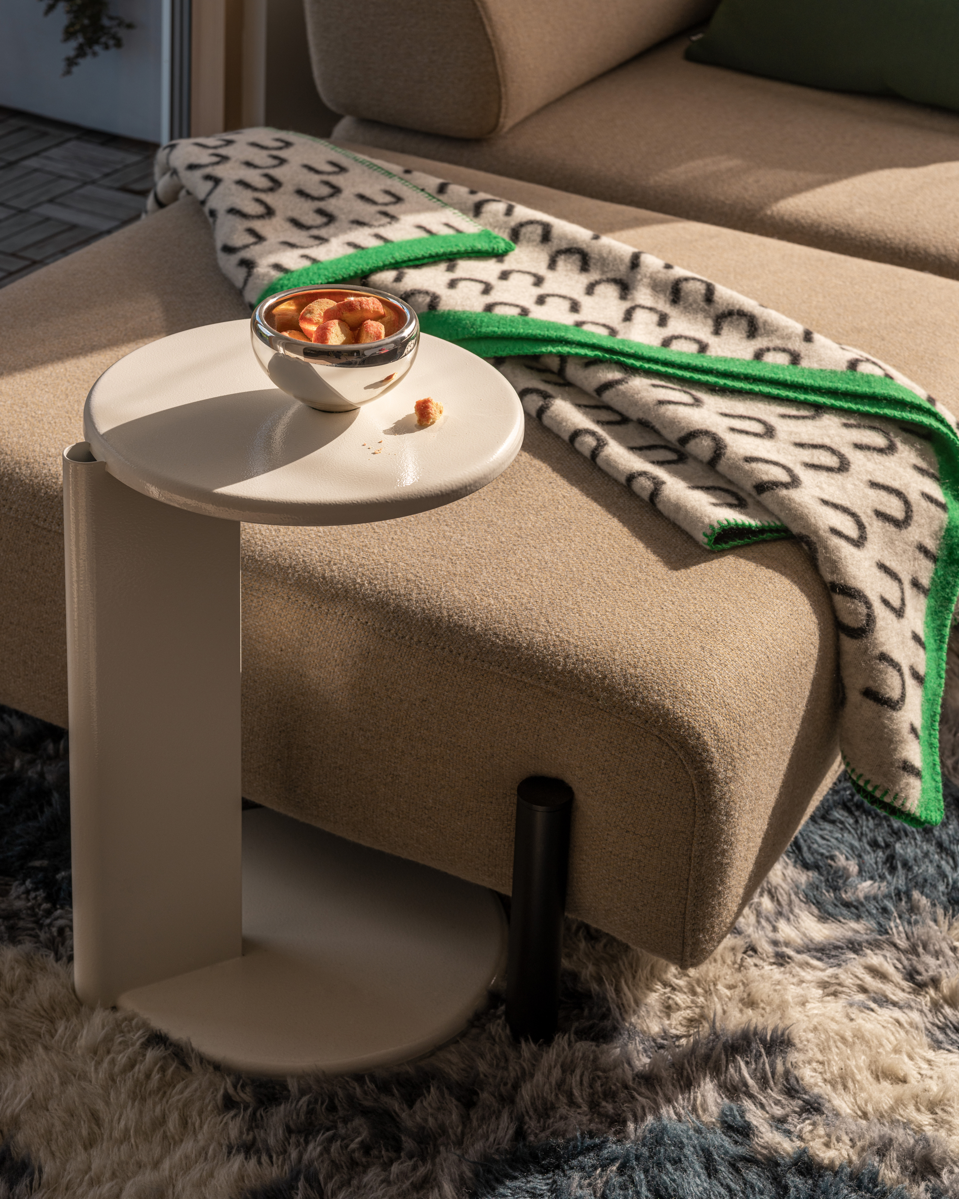 A lifestyle image of a living room scene featuring Monster Rug, Lolly Side Table, Arch Throw and Palo Modular Sofa.