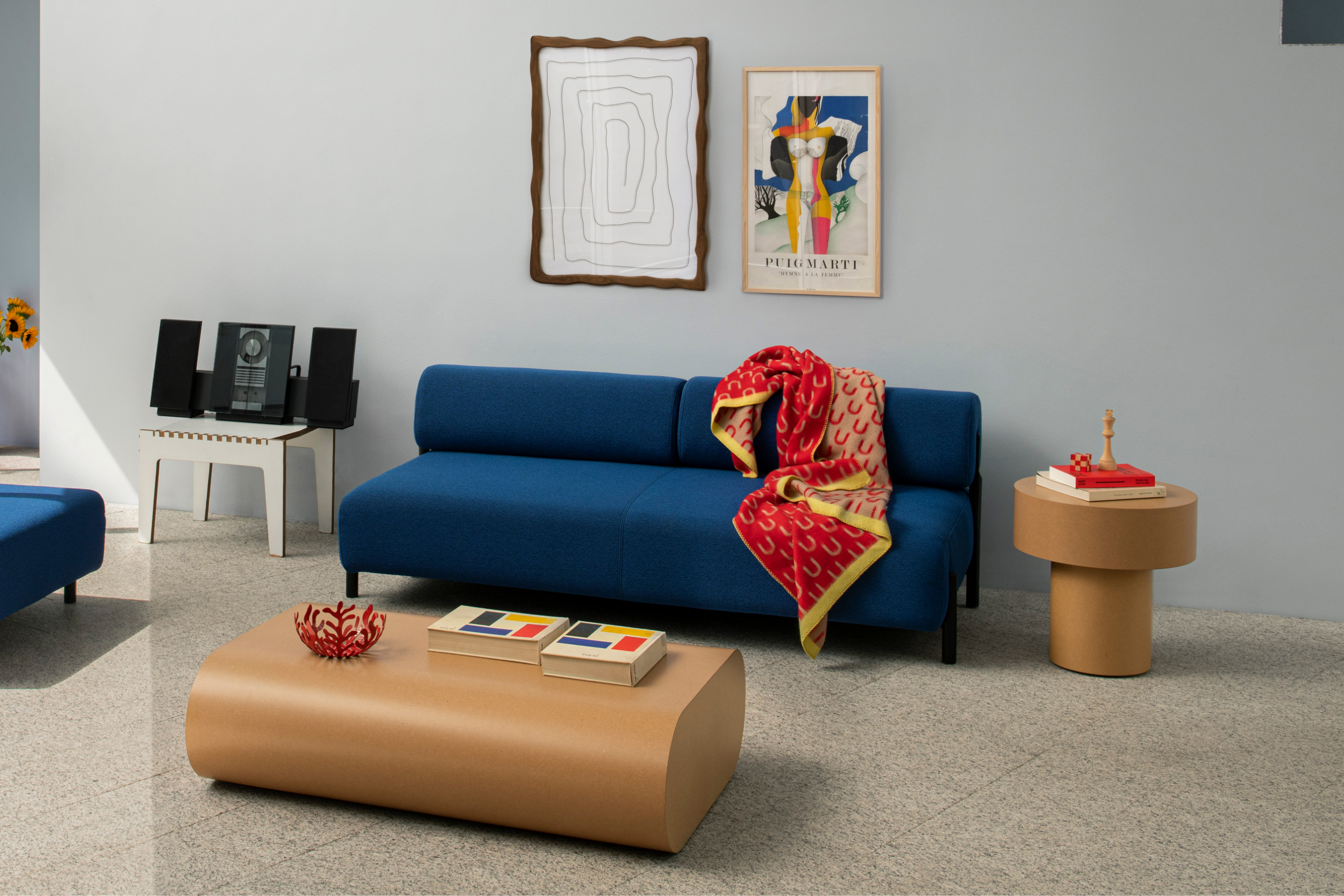 A lifestyle image of a living room scene featuring Palo Modular Sofa, Arch Throw, Wiggle Box Frame, Stump Side Table and Stump Coffee Table.