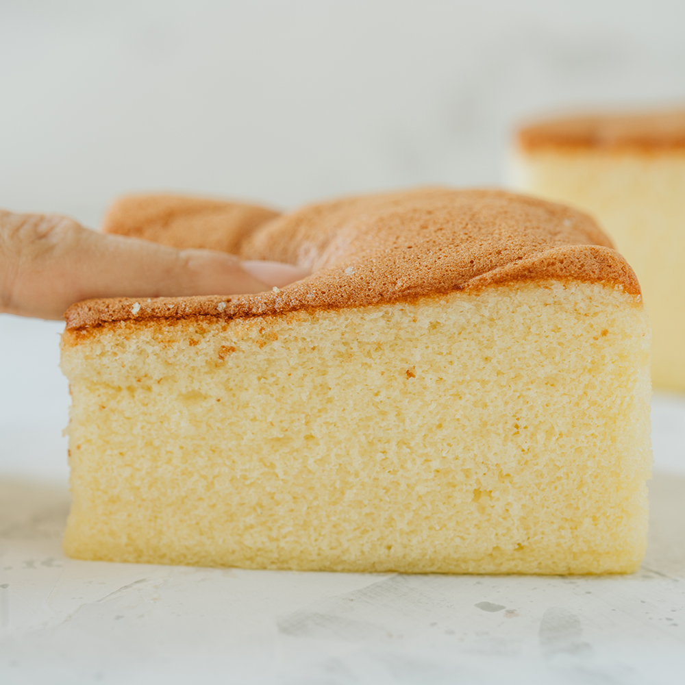 Un doigt appuie sur un cake moelleux - Aveve