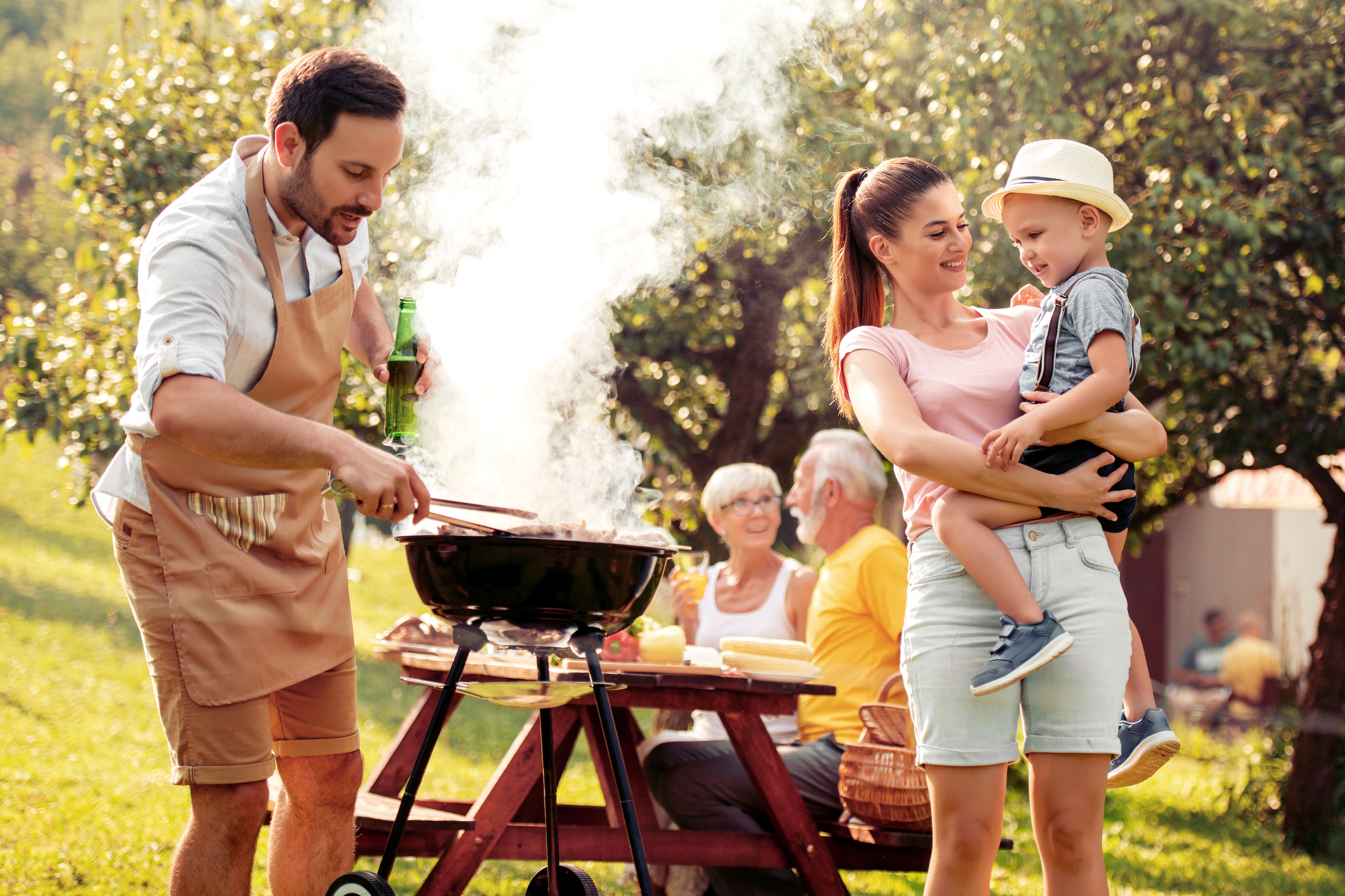 Aveve_Inspiratie_tuin_buiten-genieten_bbq_alles-voor-de-perfecte-barbecue_man-staat-te-barbecueën-voor-familie