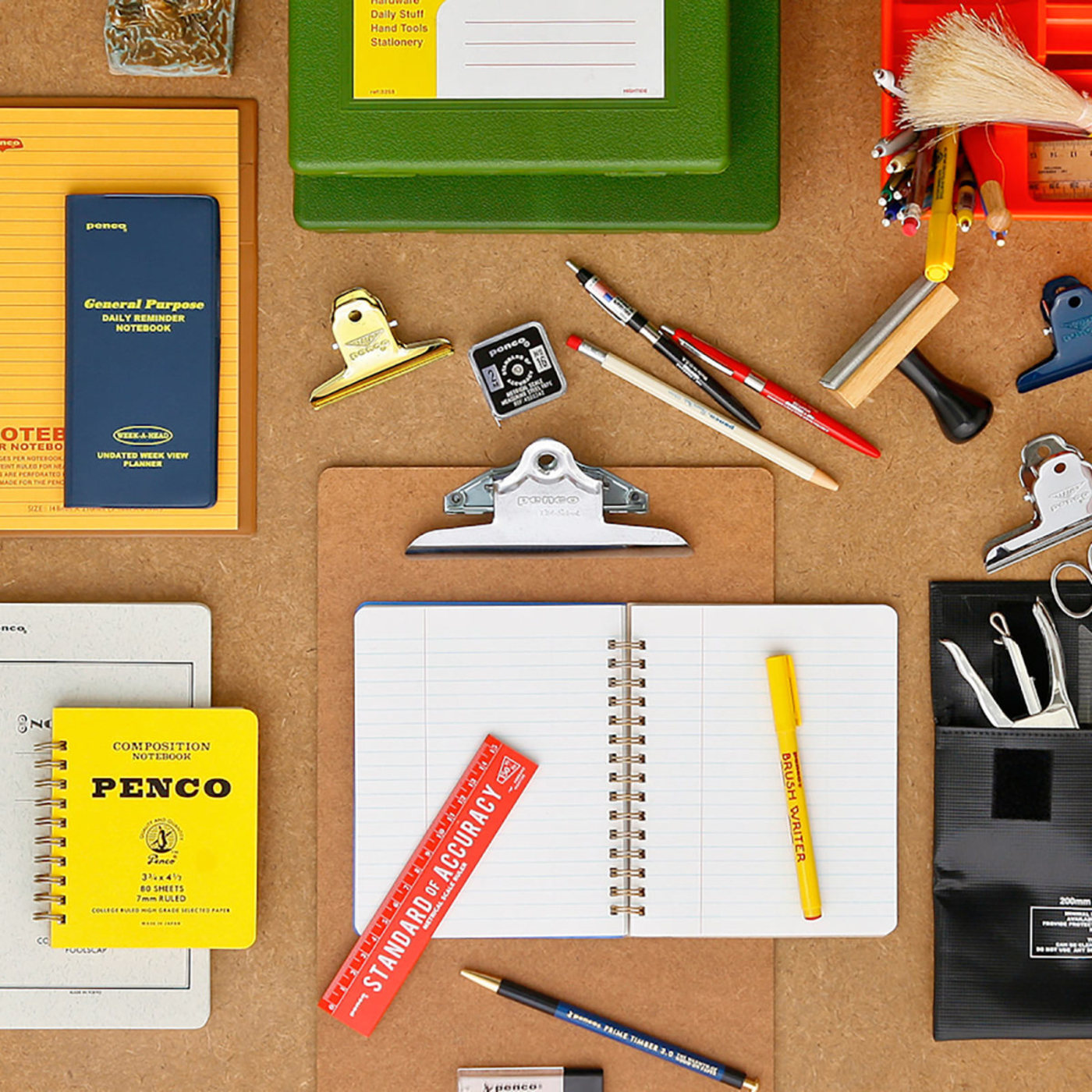 flat lay of stationery supplies: notebooks, clipboard, pens, rulers, and clips