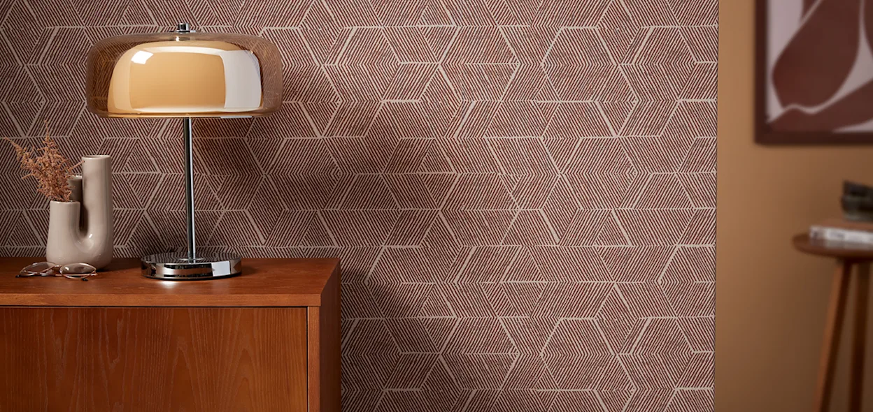 Sfeersetting van een bordeaux behang met retro uitstraling, een houten kastje en een glazen tafellamp