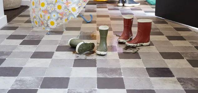 Tegellook vinyl vloer met bemodderde kinderlaarzen
