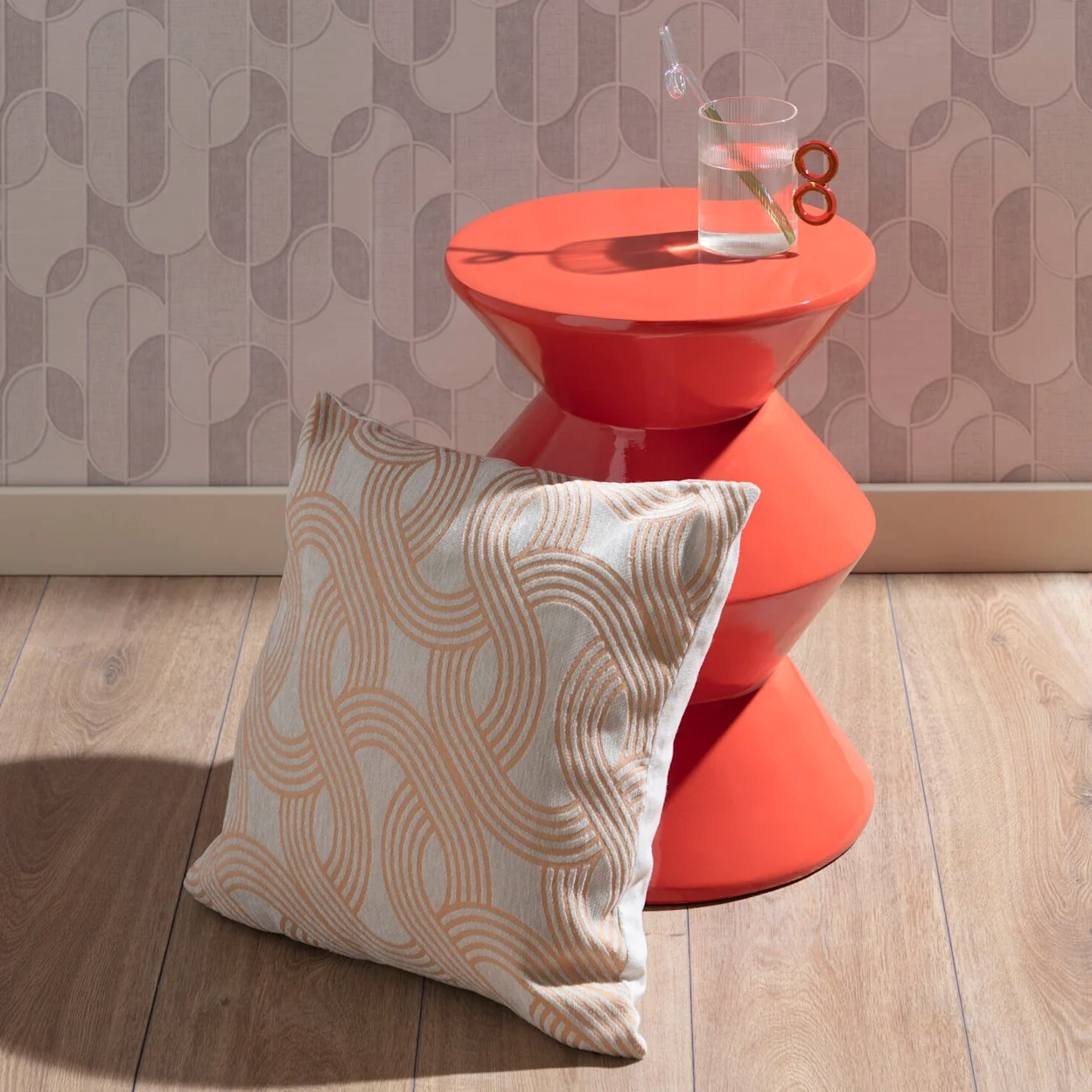 Retro sfeersetting met een oranje bijzettafel en retro chain sierkussen