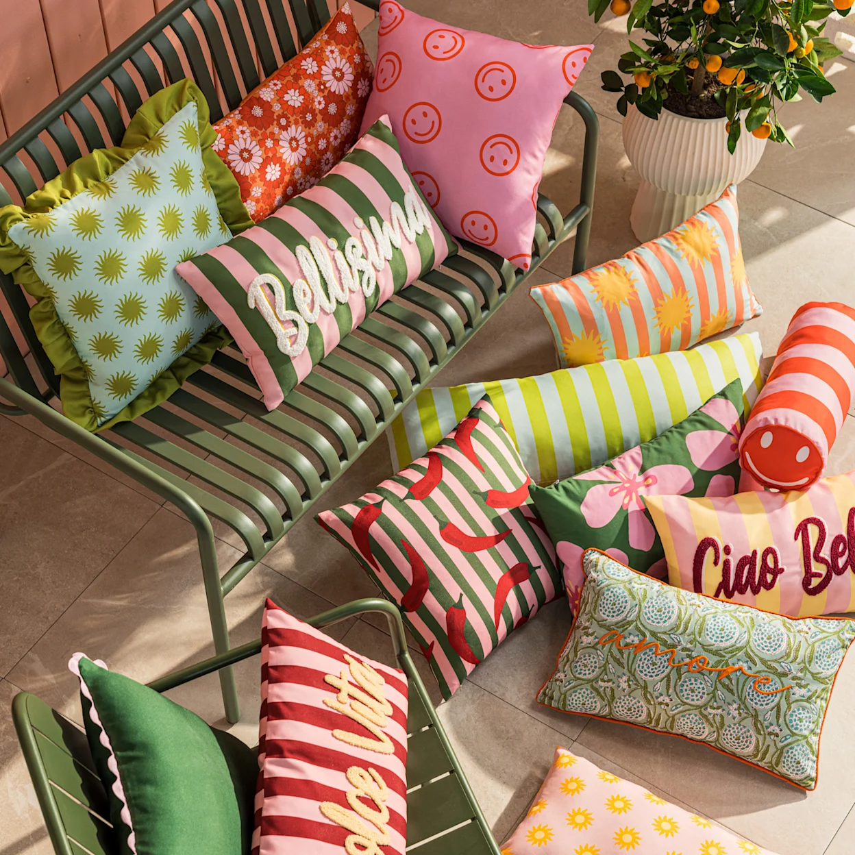 Groene tuinbank met diverse kleurrijke tuinkussens