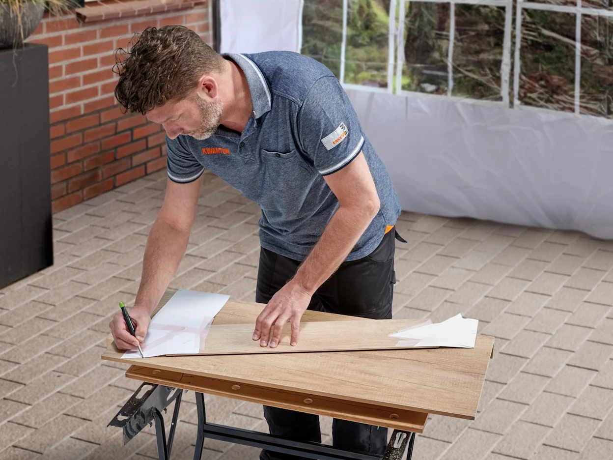 Onze traprenovatiedienst, stap 3: de mallen worden afgetekend op de laminaat traptredes en stootborden