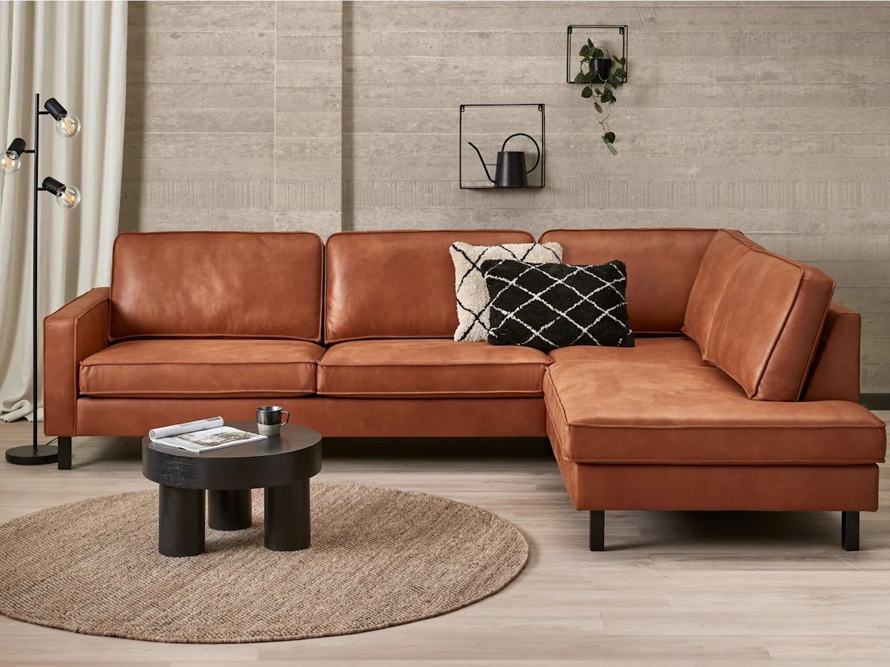 Een industriele zithoek krijgt warme met houten accessoires en sfeervolle woondecoratie