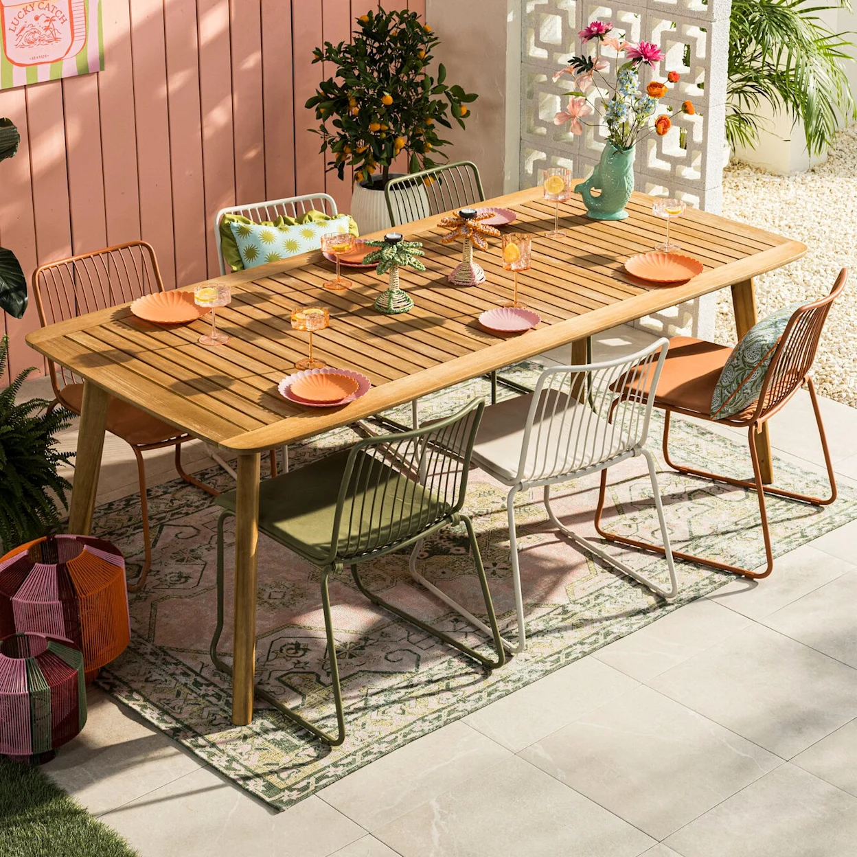 Kleurrijke tuin eethoek met een groen met roze vloerkleed met Oosterse print