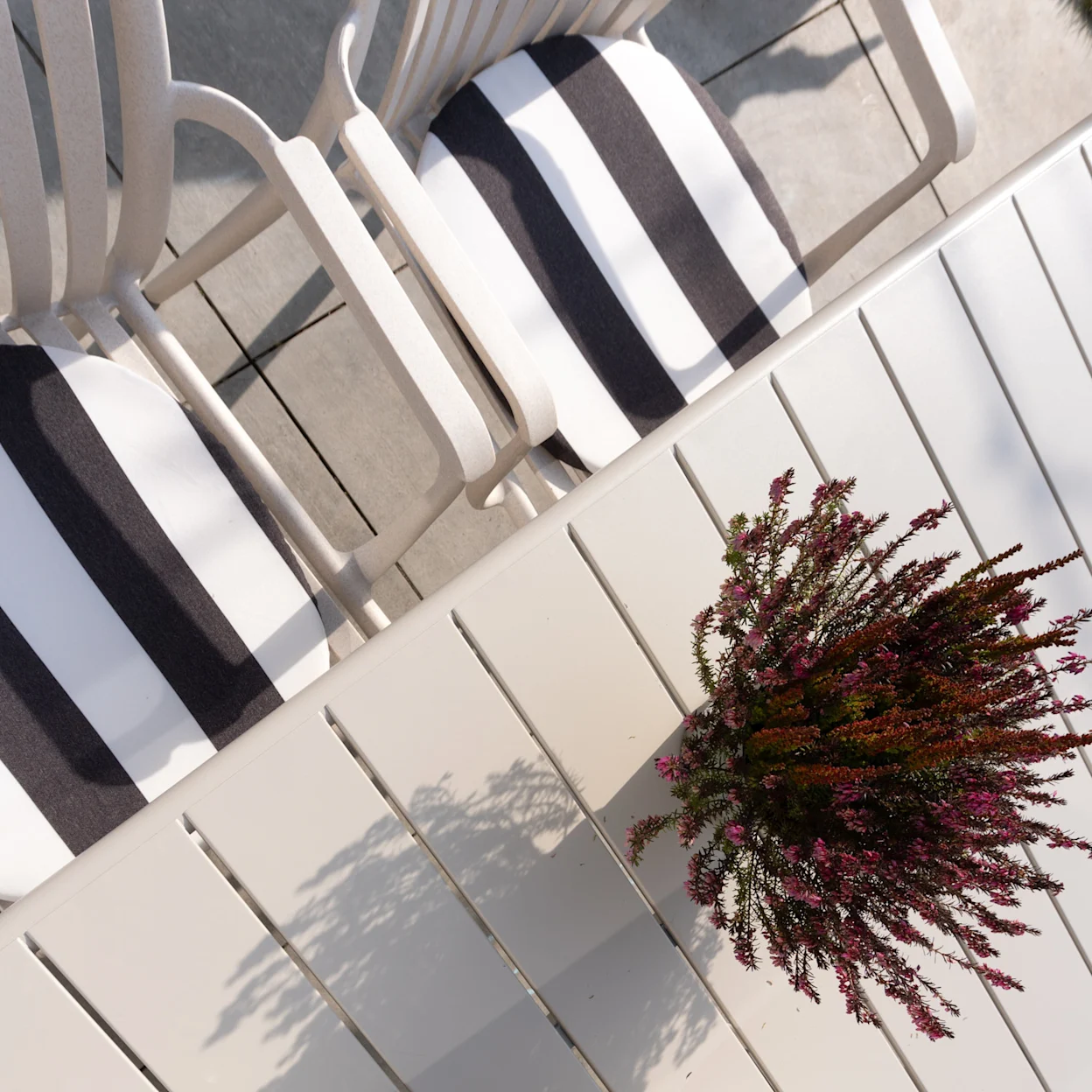Gestreepte kussens in beige tuinstoelen