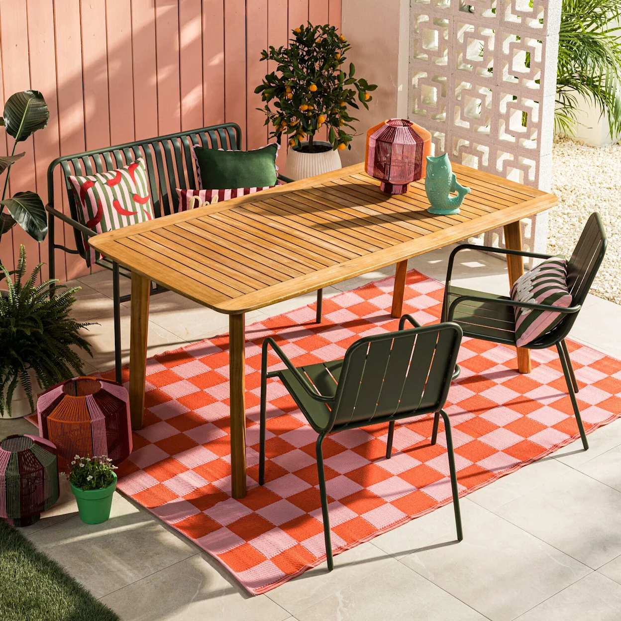 Eethoek tuin met kleurrijk geblokt buitenkleed in roze en oranje