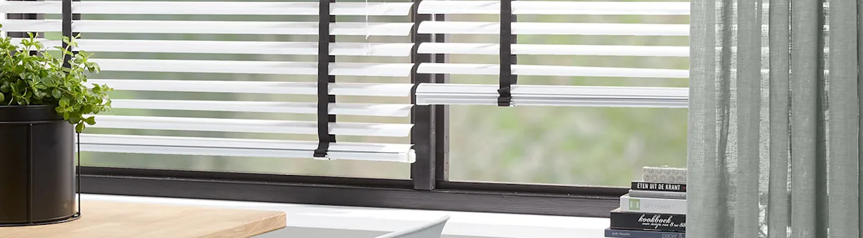 Raambekleding met contrast: witte aluminium jaloezieën met zwarte ladderband