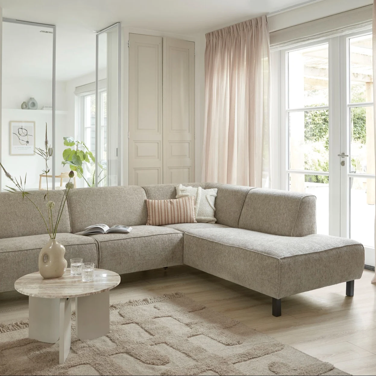 Scandinavische woonkamer met moderne bank, zachte aardetinten en natuurlijke materialen