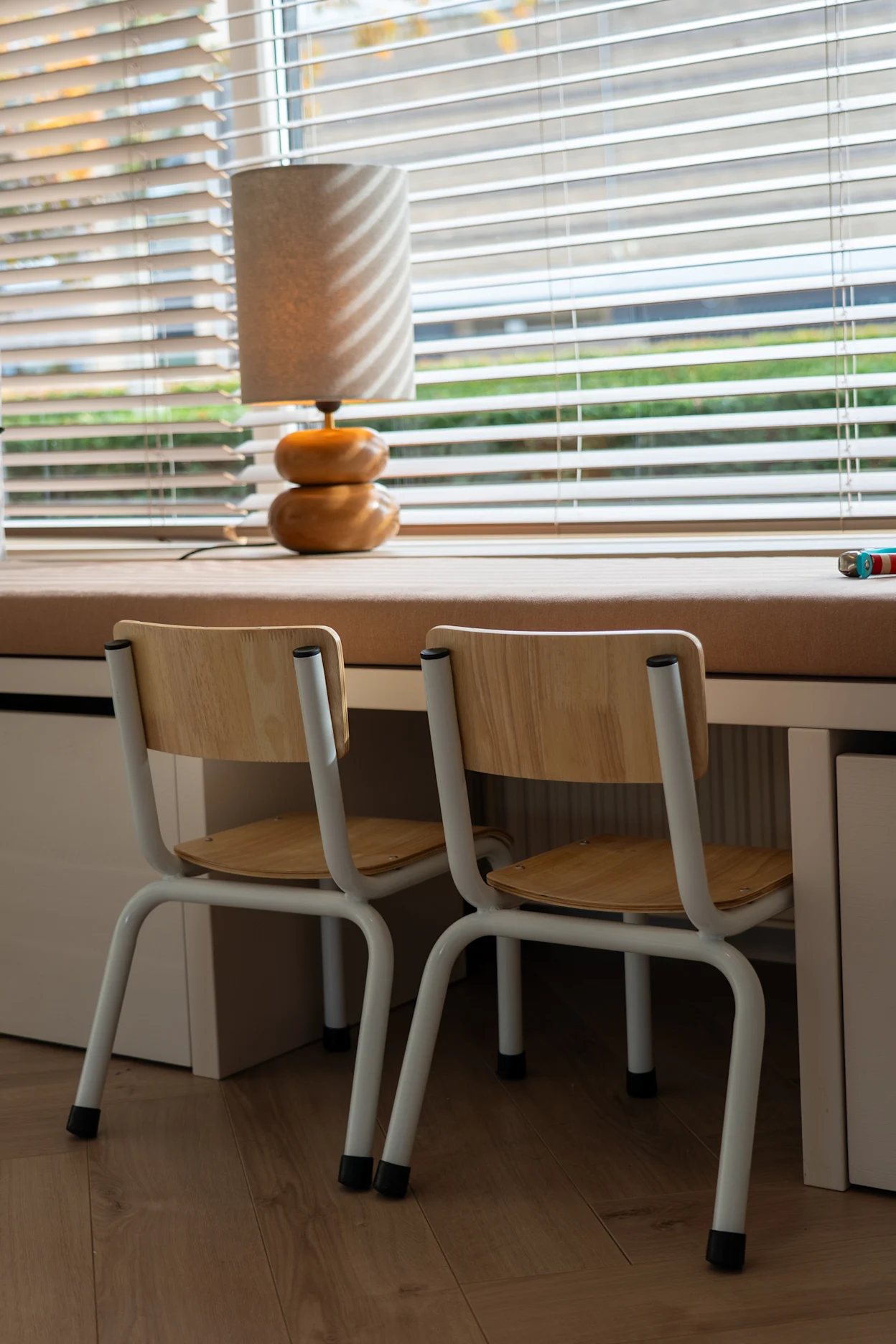 Speelhoekje voor kids met moderne kinderstoelen en jaloezieën