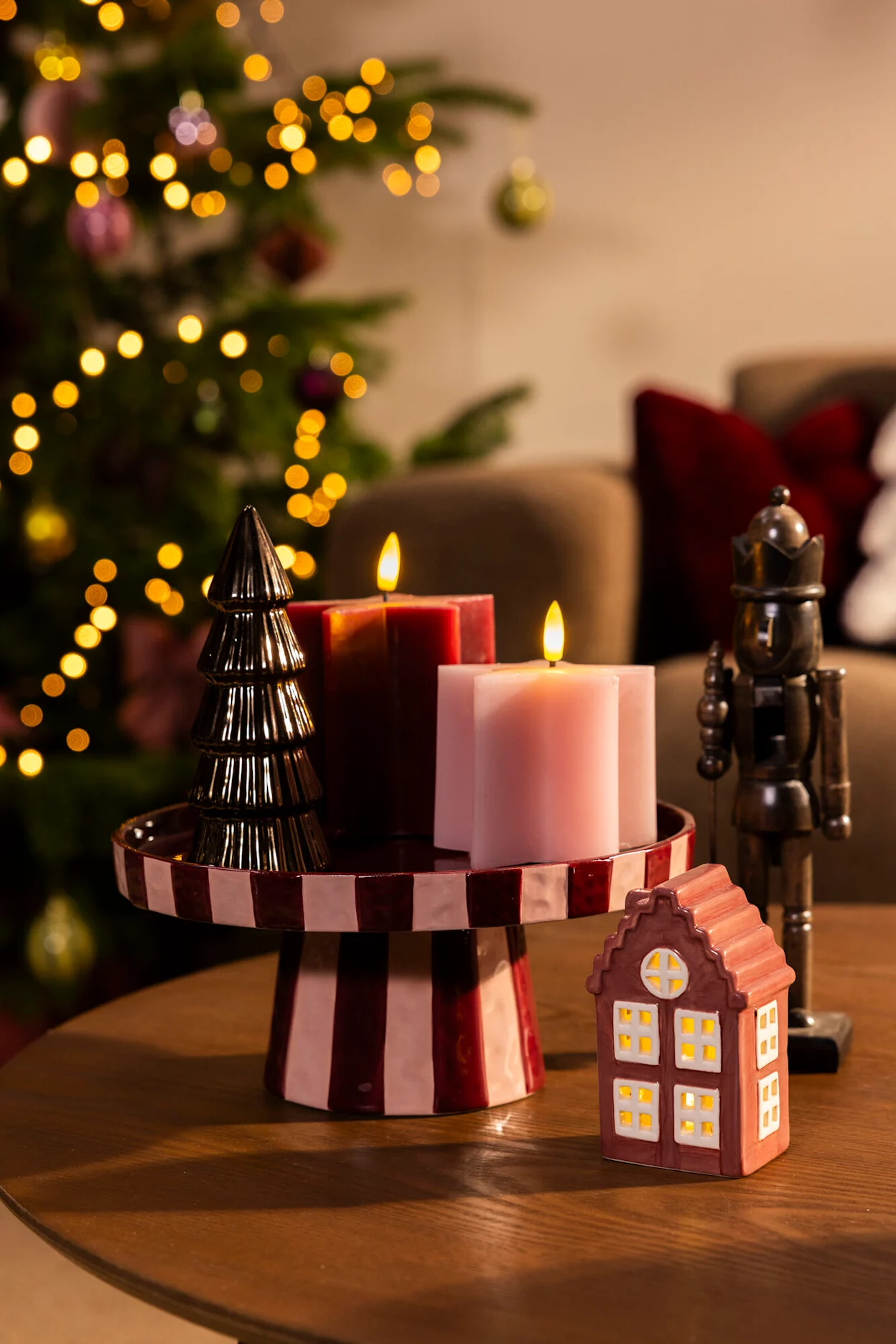 Kaarsen, een gestreept taartplateau en kerstdecoratie