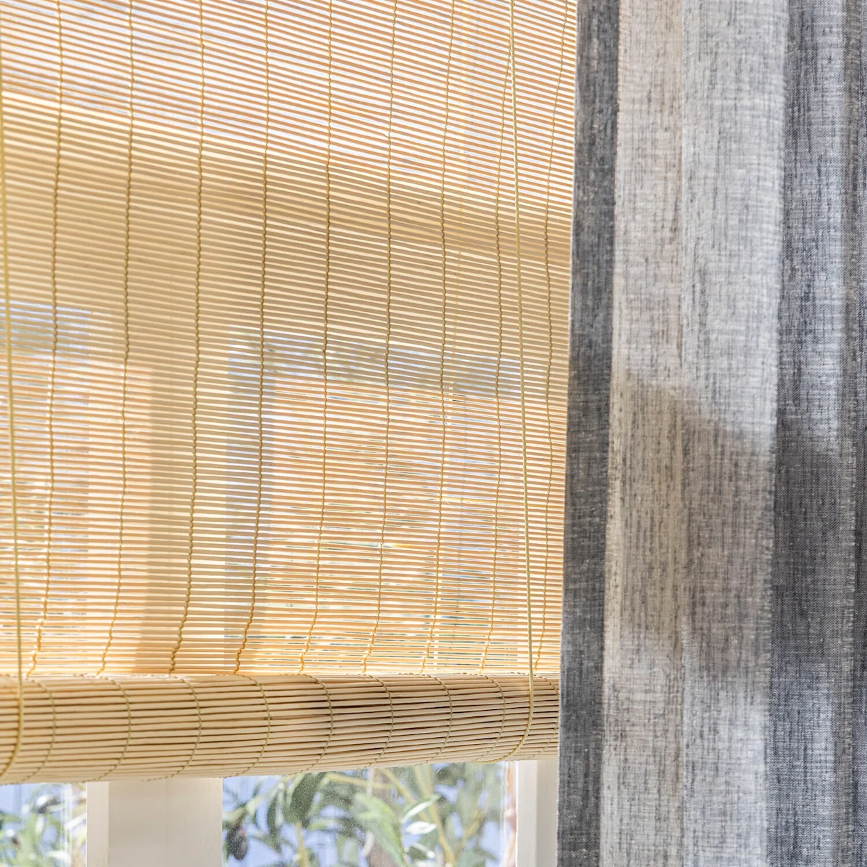 Lichte bamboe rolgordijnen als subtiele raamdecoratie in een Scandinavisch interieur