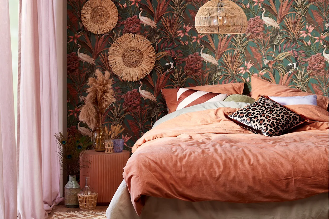 Bohemian slaapkamer setting met kleurrijke accessoires, tropisch behang en rotan verlichting en decoratie