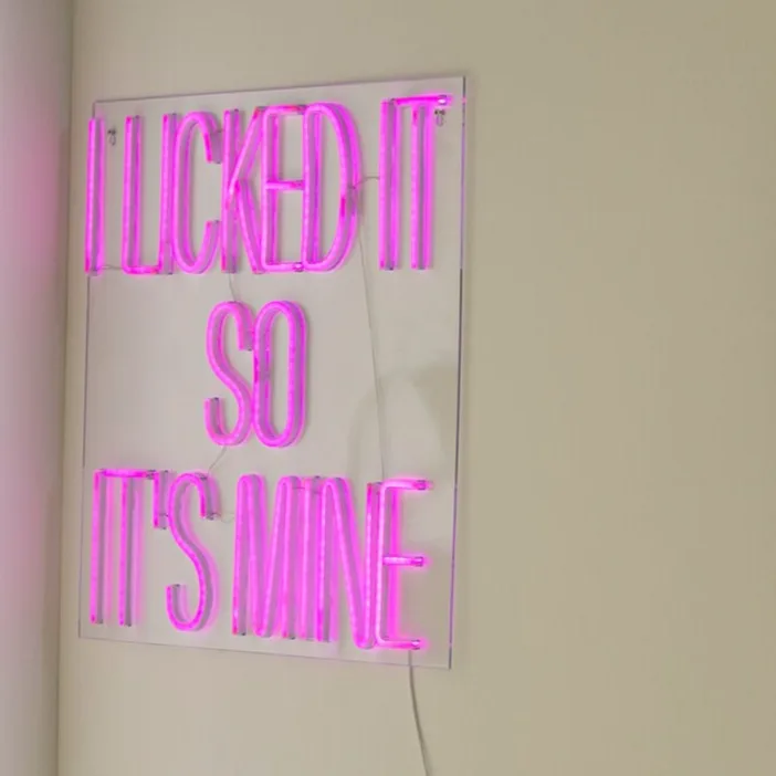 Neon wandlamp met tekst en metalen kast