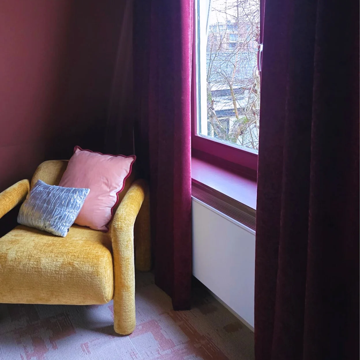 Donker rode gordijnen in de slaapkamer van Sofie de Kruijff
