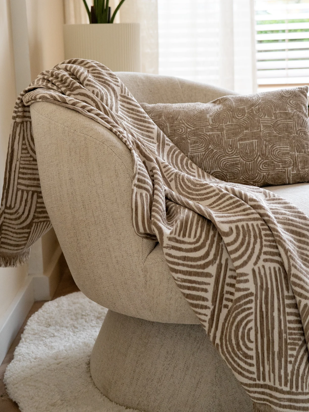 Lichtgrijze draaifauteuil met plaid met organische print