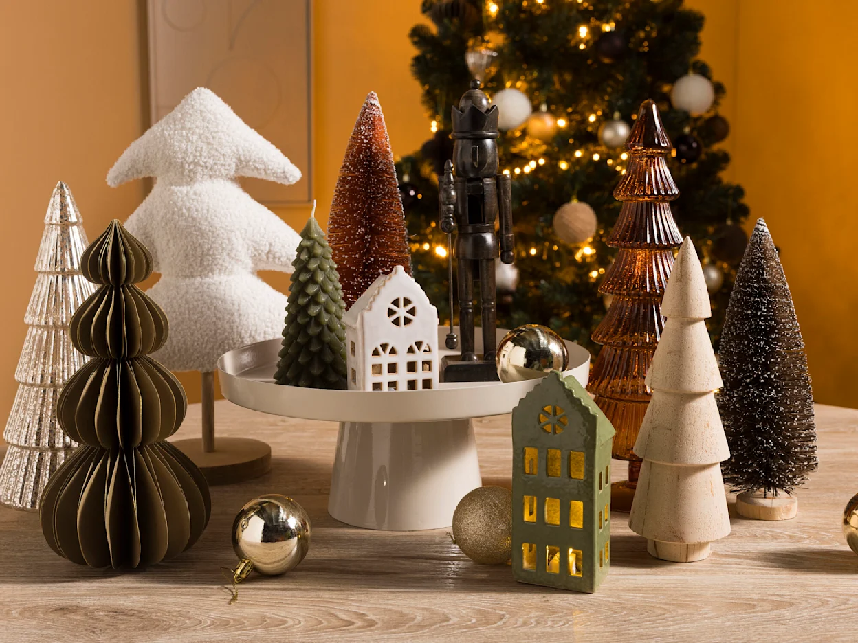 Scandinavische kerstsetting met glazen kerstboomverlichting, papieren kerstbomen en een miniatuurauto met kerstboom