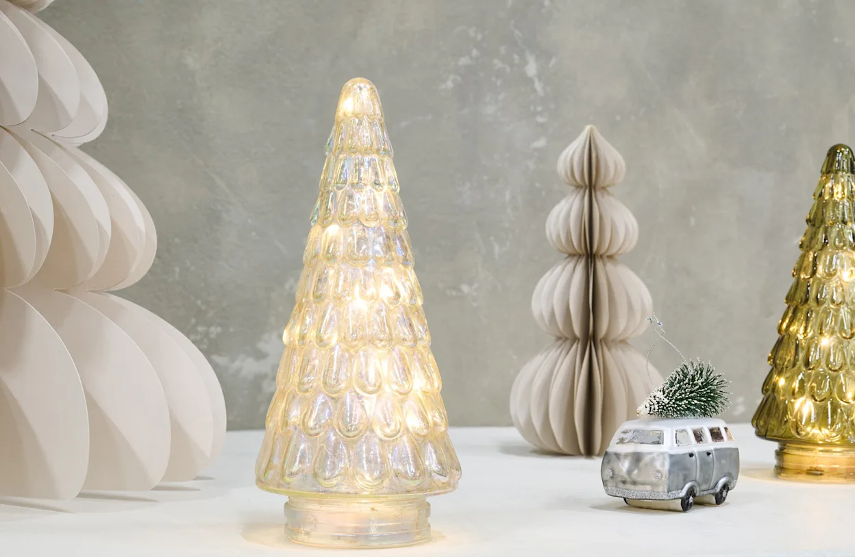 Scandinavische kerstsetting met glazen kerstboomverlichting, papieren kerstbomen en een miniatuurauto met kerstboom