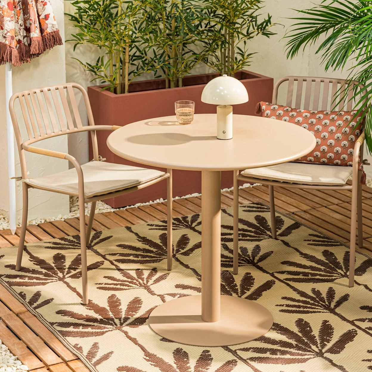 Retro zithoek met een taupe tafeltje voor twee en naturel tuinstoelen