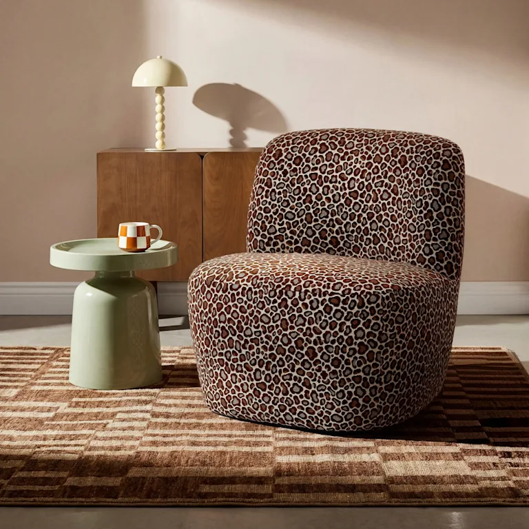 Een panterprint fauteuil in een retro interieur met opvallend vloerkleed