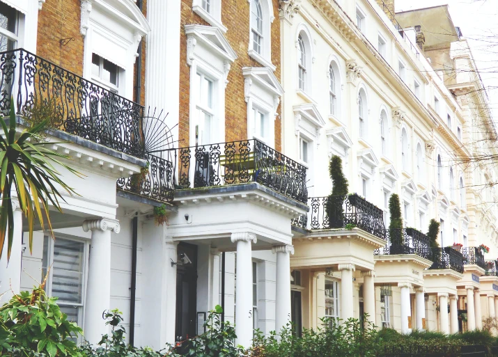Image of a row of apartment buildings with greenery around them